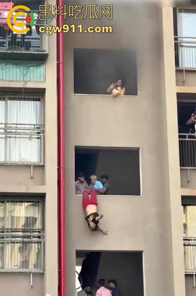 印尼某小区发生火灾，电瓶车爆燃无法下楼，两男子化身超人，在楼下窗口接孩子，实在太惊险了！-3